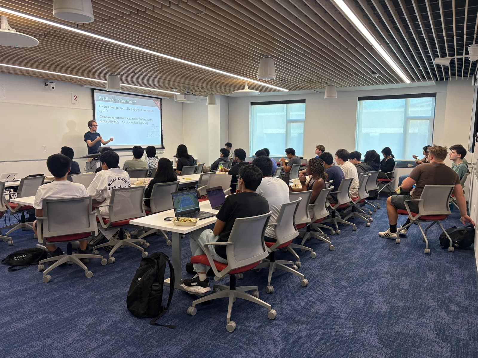Prof. Paul Gölz presenting to CAIA attendees in a Cornell classroom